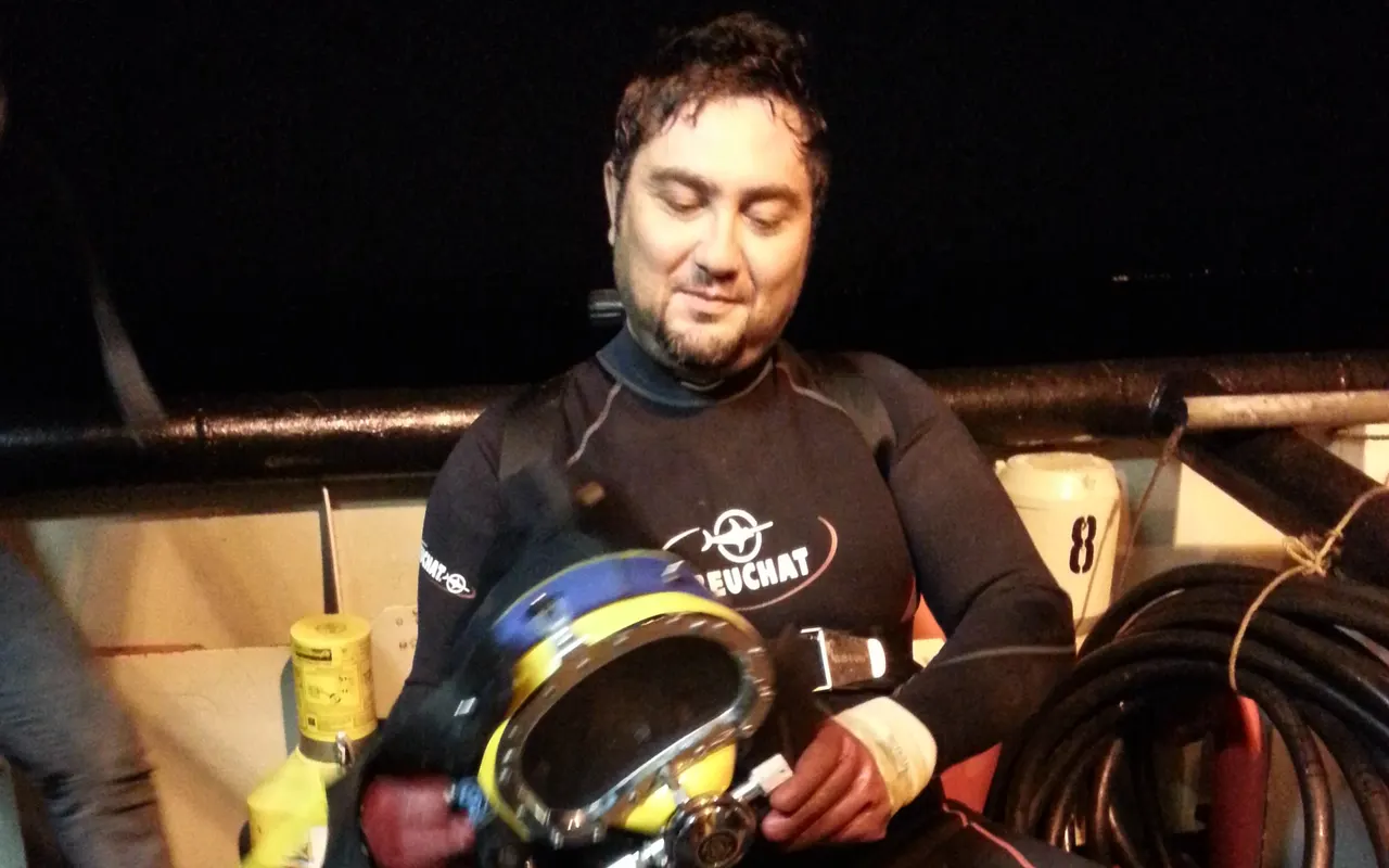Commercial diver in a Kirby Morgan 37 helmet working underwater on a hose line