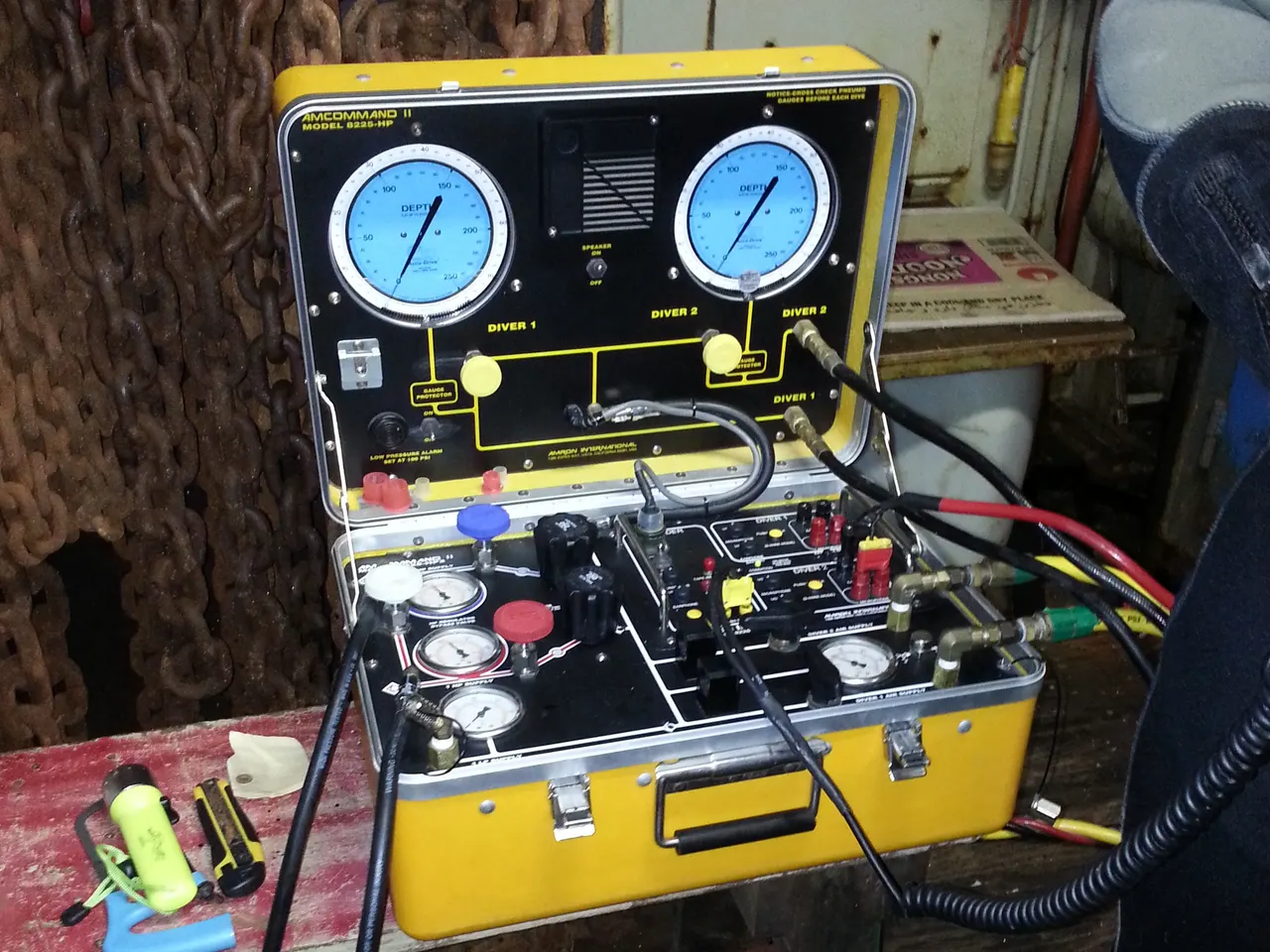 Dive supervisor at a vessel dive station monitoring surface-supplied divers entering the water